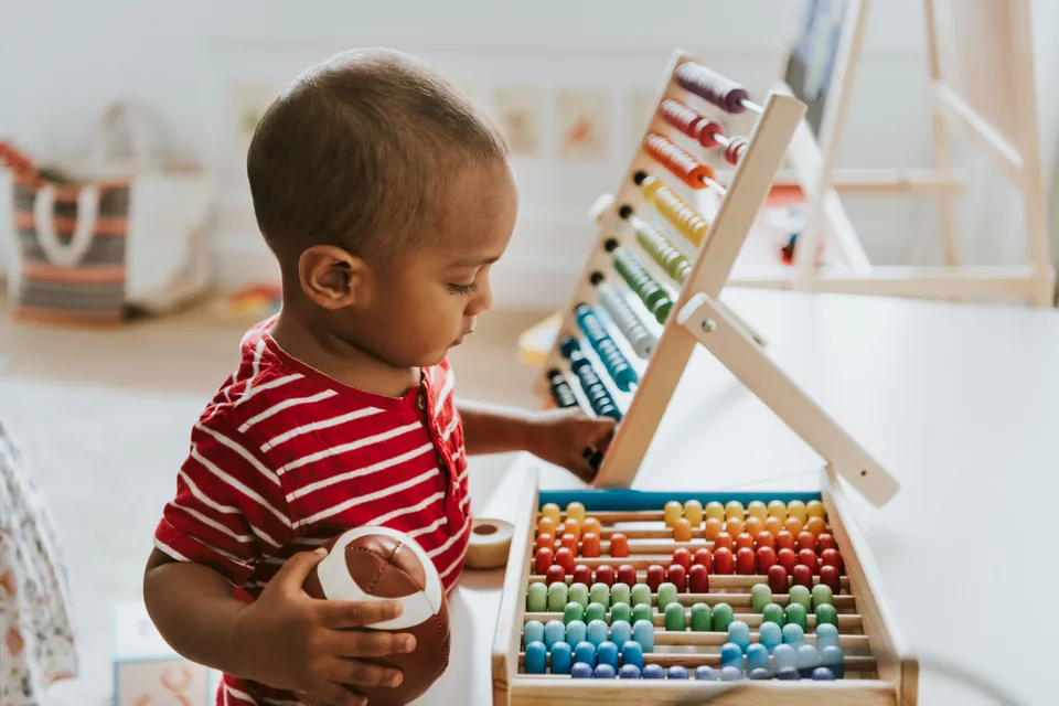 A child explores a wooden activity toy.