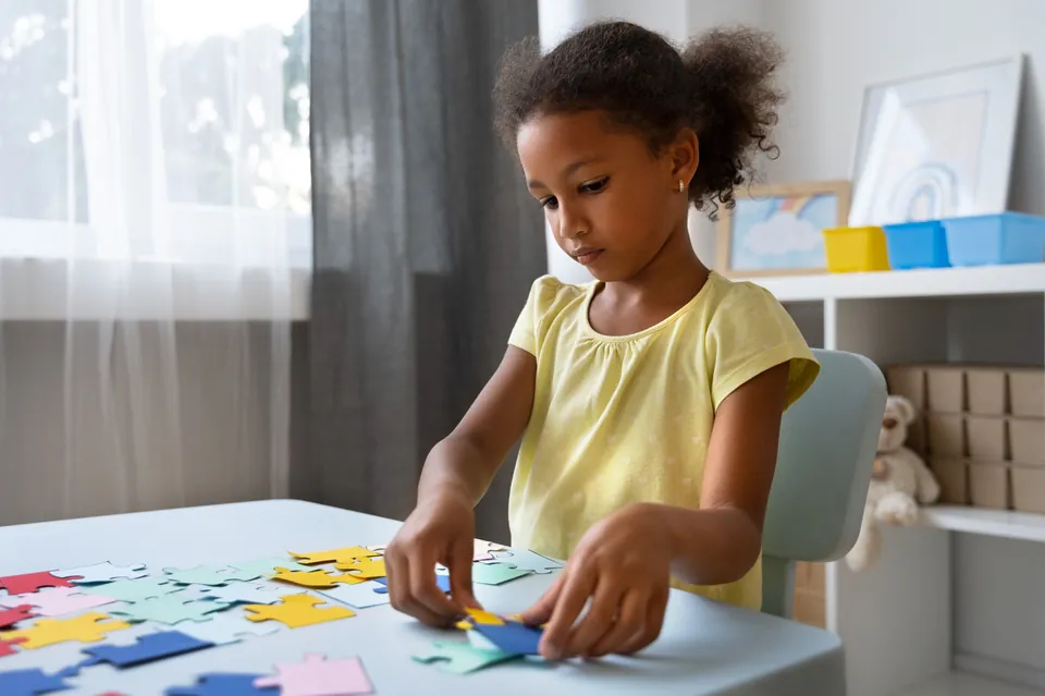 A young child explores a colorful puzzle at a table.