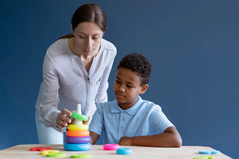 A child and an adult explore a colorful toy together.